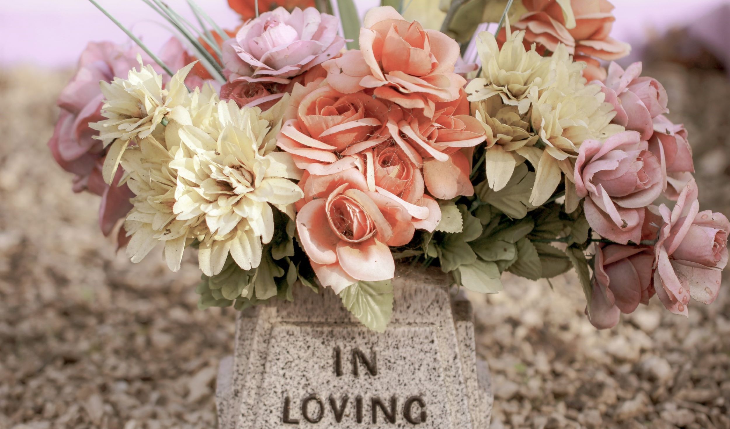 Colorful flowers are stacked upon a tomb.