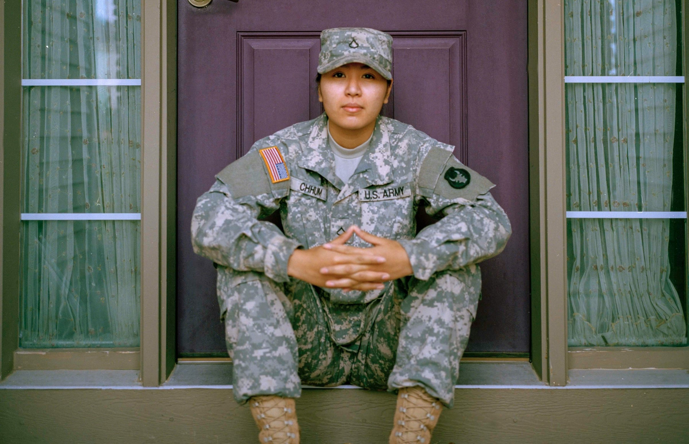 A veteran poses in front of a brown door.